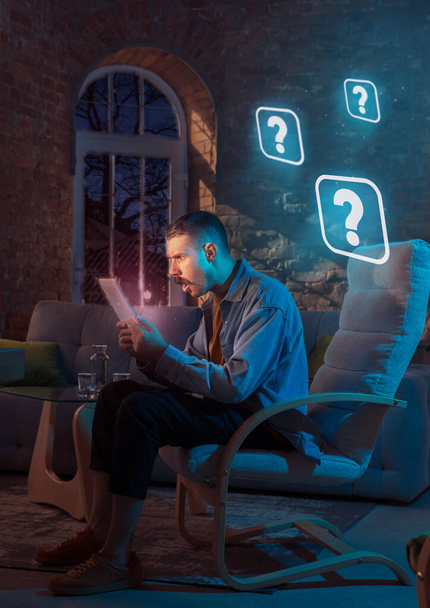 Man using gadget and receive neon notifications at home at night - Fotó, kép