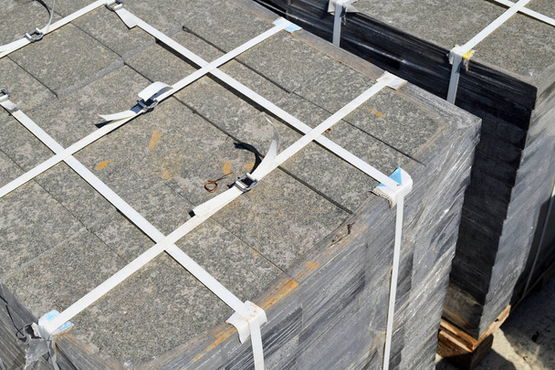Granieten tegels op pallets op een bouwplaats. - Foto, afbeelding