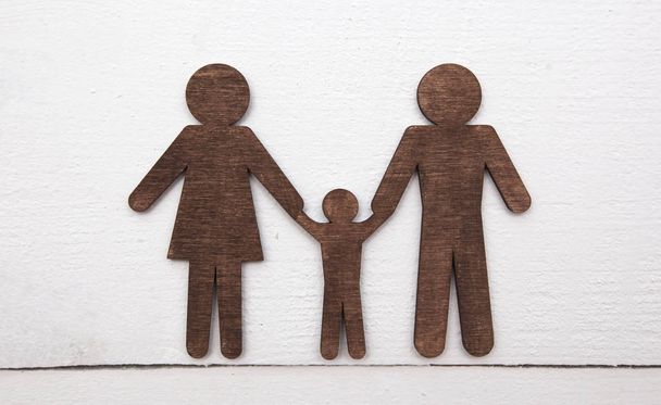 Wooden statuettes of mother, father and their child on the woode - Foto, Imagem
