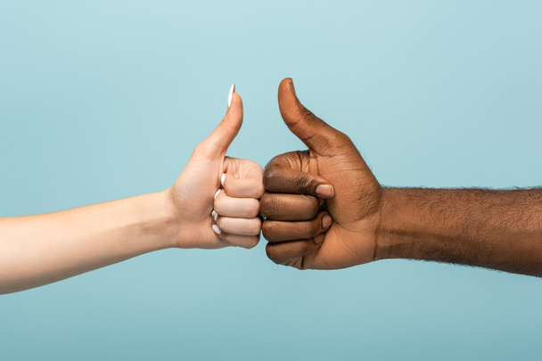 cropped view of interracial couple showing thumbs up isolated on blue - Fotografie, Obrázek