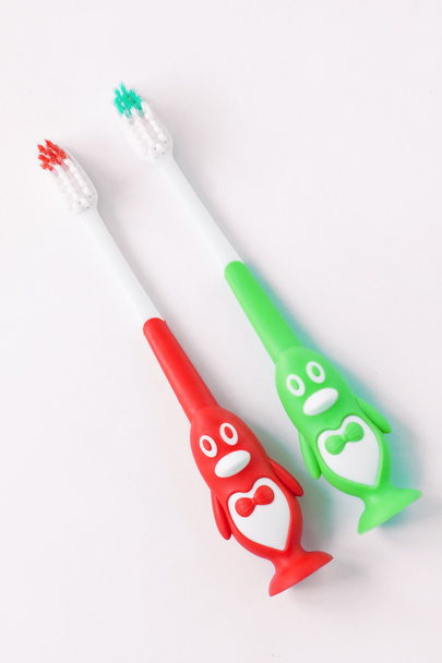 Cepillos de dientes para niños en forma de pingüinos sobre un fondo blanco aislado. Divertido enseñar a los niños a cepillarse los dientes fácilmente
. - Foto, imagen