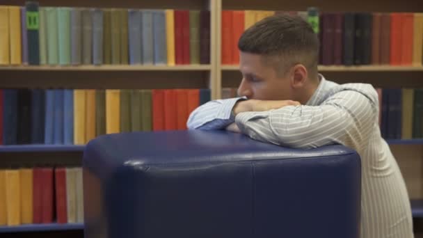 Der Typ ist traurig in der Bibliothek - Filmmaterial, Video