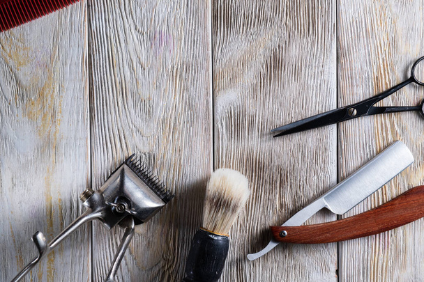 kadeřnické nůžky vintage ruční stříhání hřeben štětec nebezpečné břitva jsou na bílém ošlehaném dřevěném povrchu. - Fotografie, Obrázek