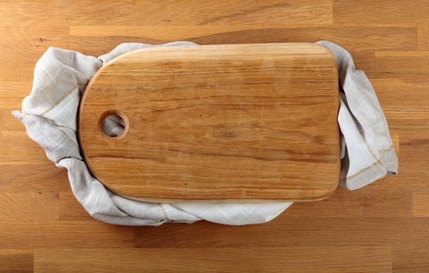 Tagliere in legno con foro circolare su un tavolo di quercia
.  - Foto, immagini