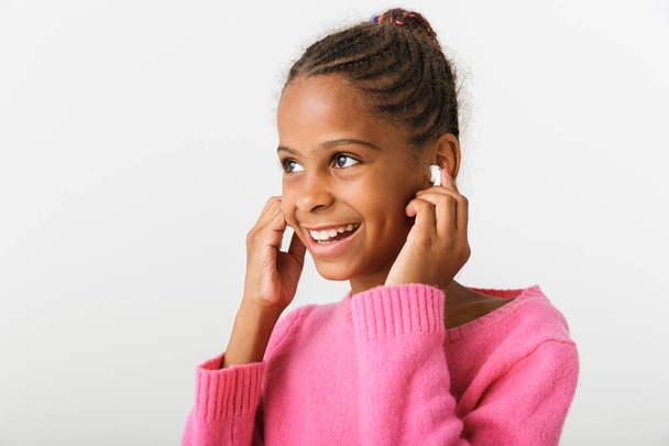Image of nice african american girl listening music with earpods - Photo, Image