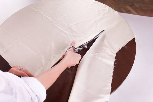 Швея режет ткань ножницами портного
 - Фото, изображение