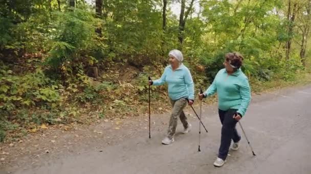 Elderly senior women practicing Nordic walking outdoors - Footage, Video