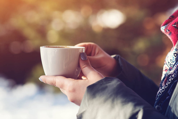 Vrouwelijke handen met een kop koffie buiten terras. Koffie pauze. Mensen, levensstijl en stemming - Foto, afbeelding