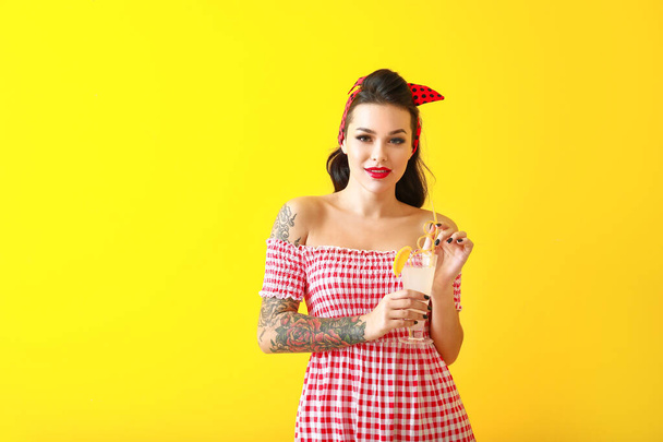 Портрет красивой татуированной женщины с коктейлем на цветном фоне
 - Фото, изображение