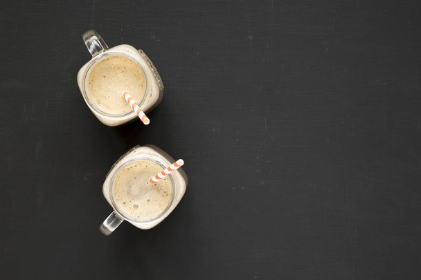 Homemade smoothie with coffee, oat and banana in glass jar mugs  - Valokuva, kuva