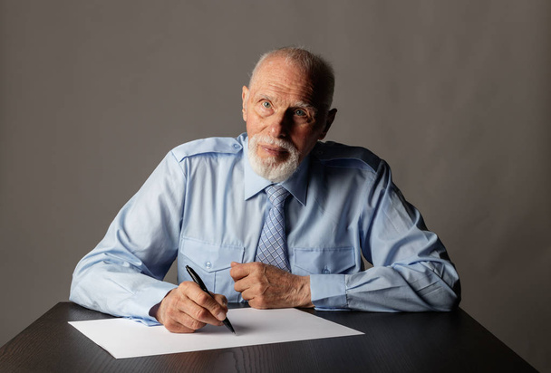 Old man is writing. - Foto, imagen