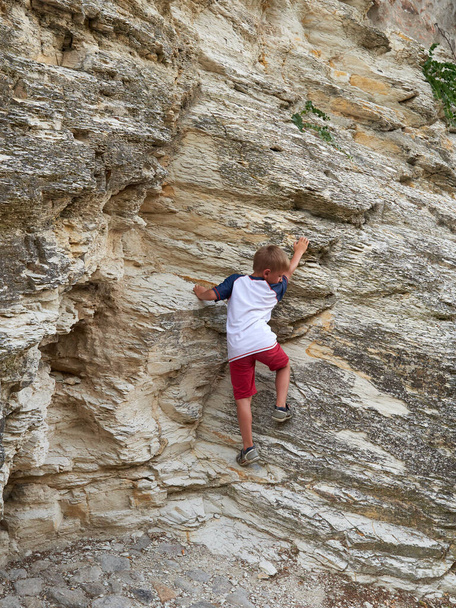 Хлопчик піднімається на скелю на вулиці старого міста Аркуа - Петрарка (Італія). - Фото, зображення