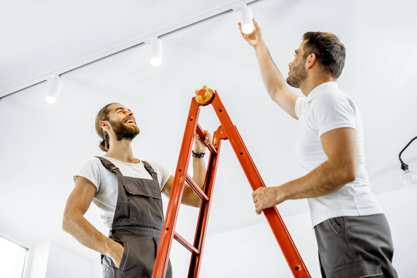 Männer installieren zu Hause Lichter - Foto, Bild