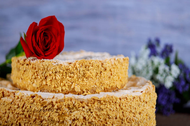 Gâteau fait maison avec des noix écrasées et des fleurs sur le fond
 - Photo, image