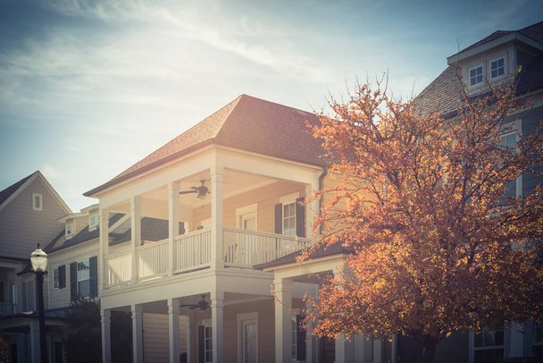 Красочные осенние листья около типичного двухэтажного дома с крышей в общежитии недалеко от Далласа
 - Фото, изображение