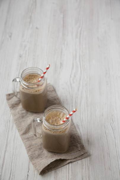 Glass jar mugs filled with coffee, oat and banana smoothie on a  - Photo, Image