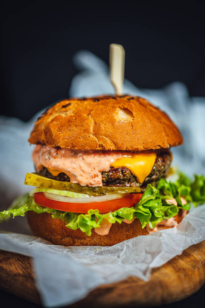 Σπιτικό cheeseburger με μαρούλι, μοσχαρίσιο κρέας και πάπρικα. - Φωτογραφία, εικόνα