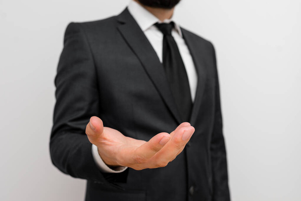Male human with beard wear formal working clothes raising one hand up. Man dressed in work suit plus tie raised fore indexfinger. photo of silent and permission - Foto, Imagen