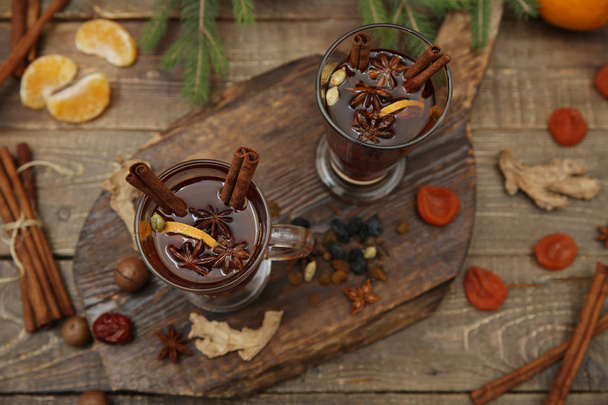 mulled wine hot drink or tea with spices and spices on a wooden background with a branch of spruce. Traditional winter drink. Christmas concept, background, banner, menu. Top view. Flat lay. - Photo, Image