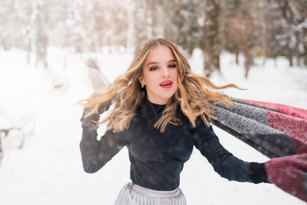 Weihnachten, Neujahr, Winterurlaub. Nettes Teenager-Mädchen mit lockigem Haar. Spiel mit Schnee im Park. - Foto, Bild