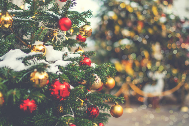 Açık havada süslenmiş, arka planda bulanık bir Noel ağacı. Metnin için fotokopi alanı olan bir Noel tatili. Vintage filtr etkisi. - Fotoğraf, Görsel