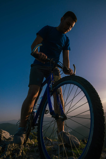 Acercamiento silueta de un atleta (ciclista de montaña) montando su bi
 - Foto, imagen