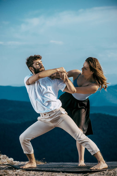 Cute couple of young hip-hop dancers. Young casual man and woman performing modern dance in nature. School of dance art - Φωτογραφία, εικόνα