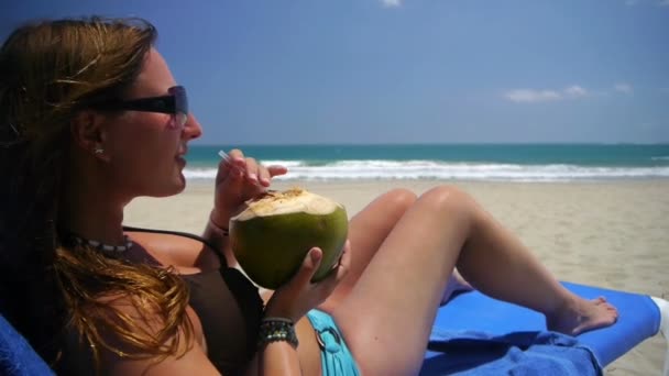 Meisje drinken kokosmelk op strand - Video