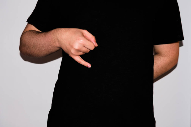 Молодой сурдопереводчик, показывающий букву "J" на американском языке жестов
 - Фото, изображение