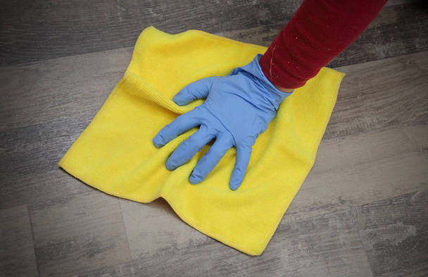 Hand in glove cleaning laminate floor - Фото, изображение