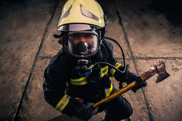 Ritratto di un pompiere donna mentre tiene in mano un'ascia e indossa
 - Foto, immagini