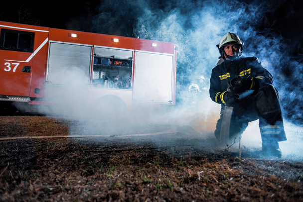 Пожарная бригада борется с лесным пожаром с помощью различных инструментов для ликвидации огня - Фото, изображение