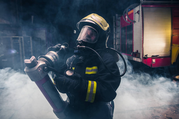 Retrato de uma mulher bombeira usando um capacete e toda a segurança
 - Foto, Imagem