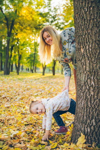 madre con hija se asoma del árbol - Foto, Imagen
