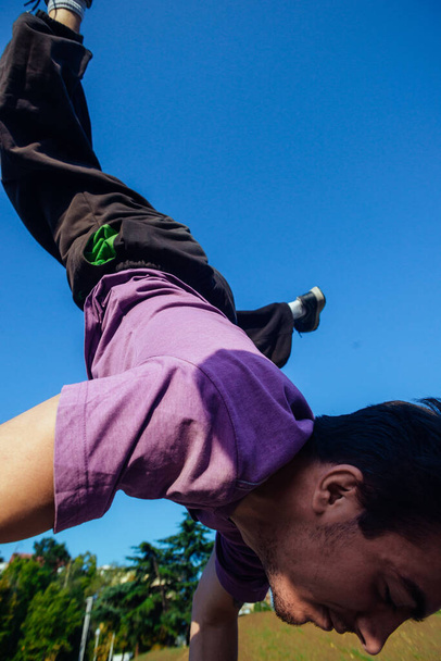 Movimientos de Parkour realizados por un tipo acrobático en el parque infantil local de skate
 - Foto, imagen