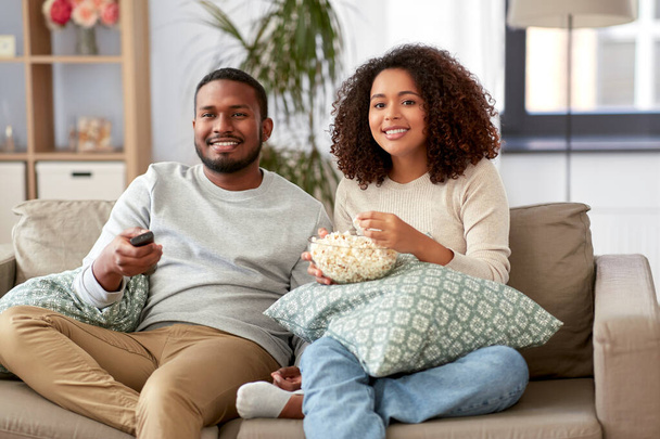 african couple with popcorn watching tv at home - Φωτογραφία, εικόνα