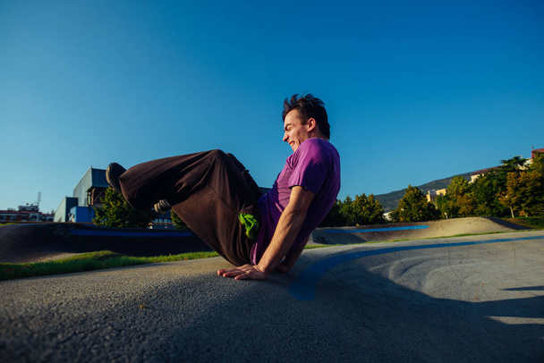 Acrobat praticando exercícios de parkour no parque de skate local
 - Foto, Imagem