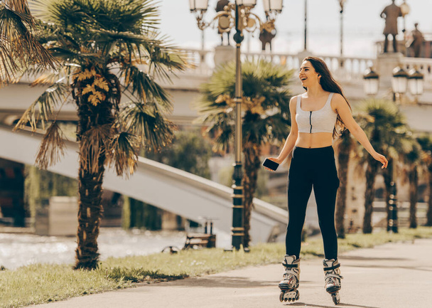 Adorable girl roller skating on the boardwalk - Foto, immagini