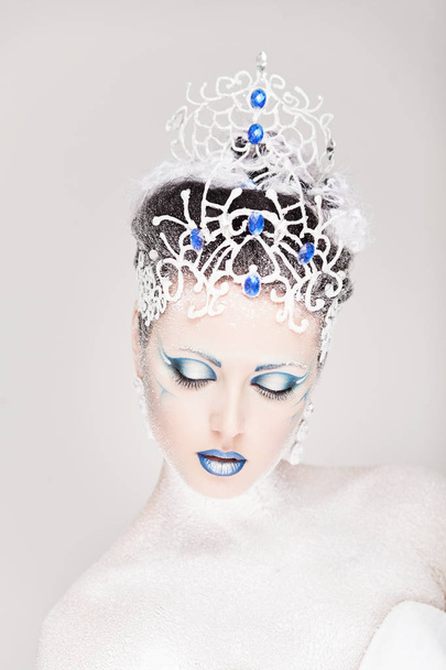 新年のための創造的な化粧を持つ美しい女の子。冬の肖像画明るい色、青い唇、エレガントなドレスのデザインの髪。概念芸術。雪の女王. - 写真・画像
