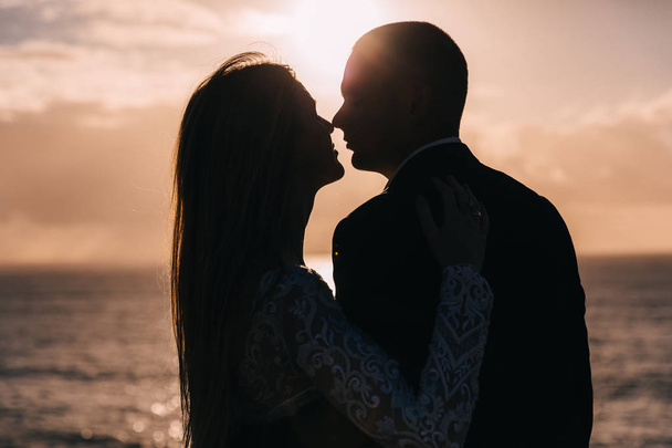 Detailní záběr novomanželů v náručí a polibek. západ slunce a - Fotografie, Obrázek