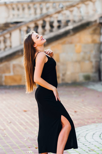 profile of girl in stylish black dress with closed eyes on stair - Valokuva, kuva