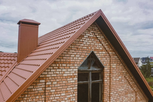 Hermosa casa de ladrillo rosa y techo naranja. Corrugado met
 - Foto, Imagen