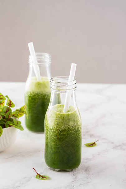Blended green smoothie with ingredients on the white table. - Zdjęcie, obraz