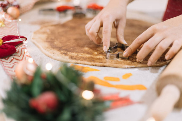Lady shaping CHristmas man biscuits in cookie dough. - Φωτογραφία, εικόνα