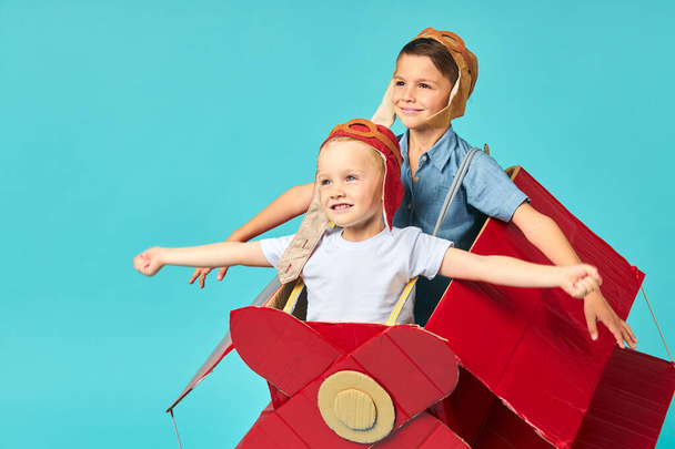 Beautiful dreamer boys flying in cardboard airplane. Childhood. - Φωτογραφία, εικόνα