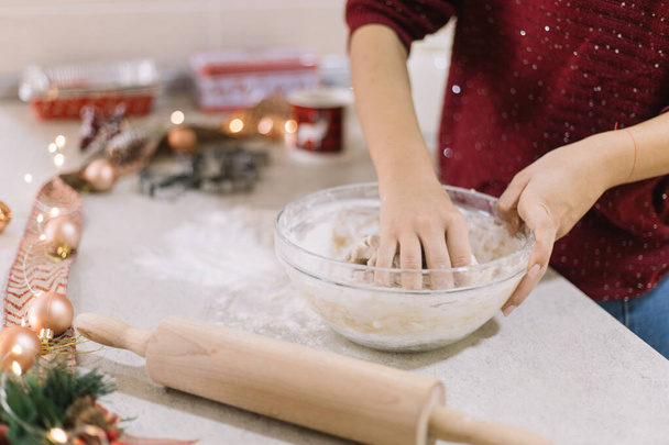 Female hands kneading gingerbread dough in bowl - Foto, afbeelding