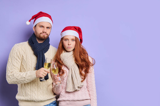 redhaired woman and unshaven man in satna claus hat - Фото, изображение