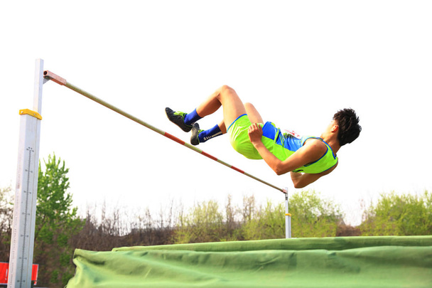 Un atleta masculino está en el salto alto
 - Foto, Imagen