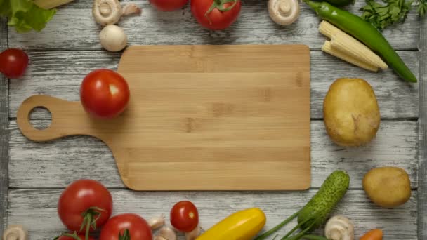 野菜と古いテーブルの上に木製のまな板上のスローモーションで回転トマト. - 映像、動画