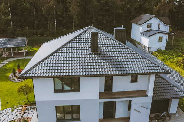 Casa con tetto in metallo grigio. Copertura in metallo ondulato e metallo ro
 - Foto, immagini